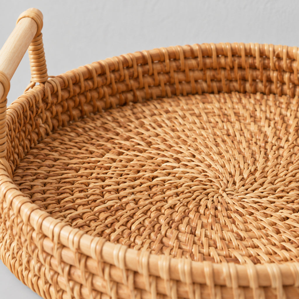 Close up of the spiral weave of the rattan base of the natural rattan round woven serving tray.