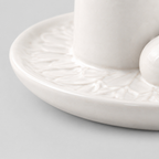Close up of the smooth rounded rim of the dish of the white ceramic incense and candle tray