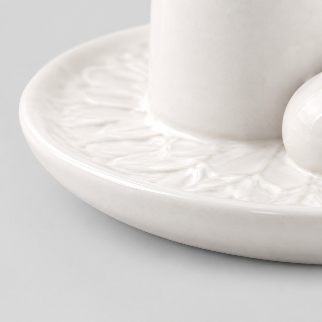 Close up of the smooth rounded rim of the dish of the white ceramic incense and candle tray