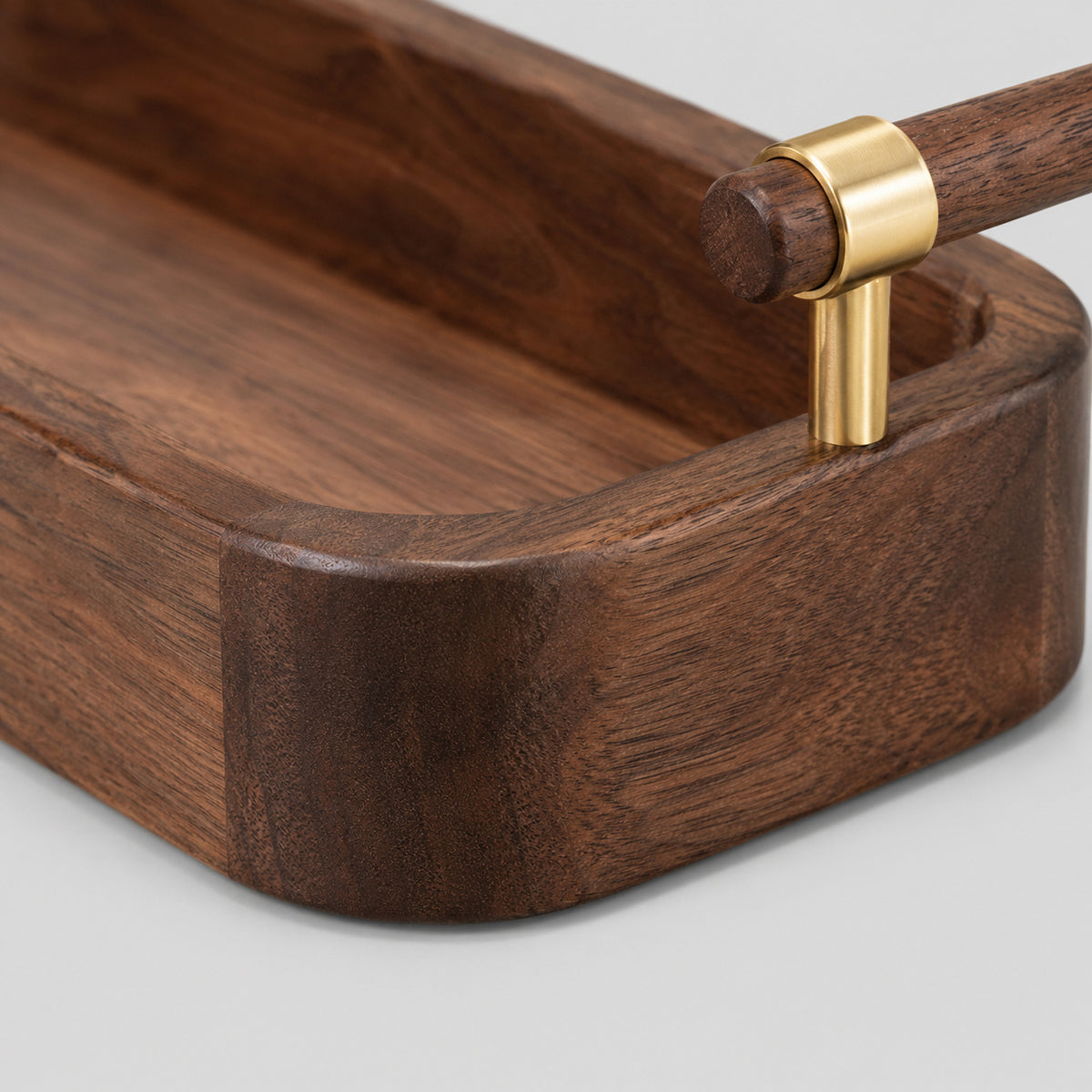 Close up of the rounded corner joint of the solid walnut rim of the serving tray.