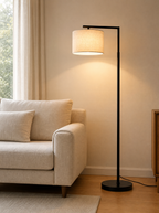 Arc floor lamp lit over the end of a linen sofa in a living room