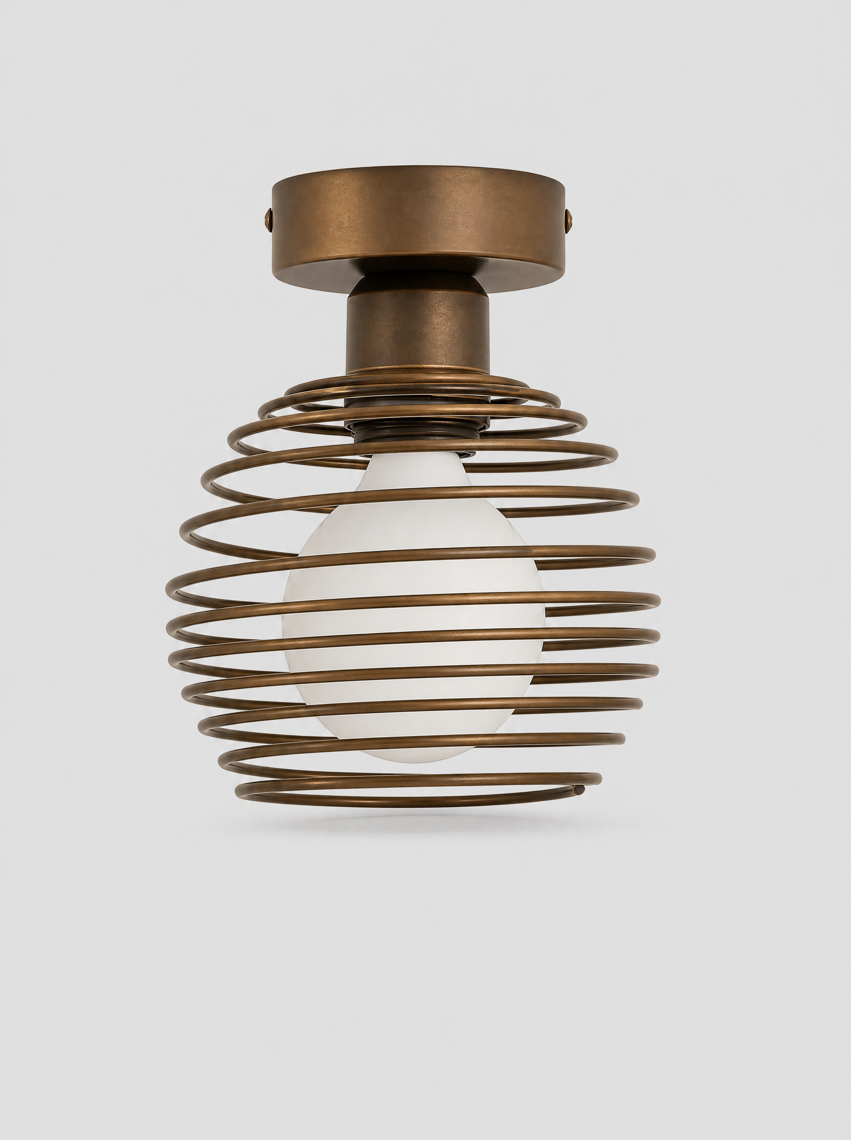 Black coiled metal flush ceiling light with an opal glass globe on a light gray studio background