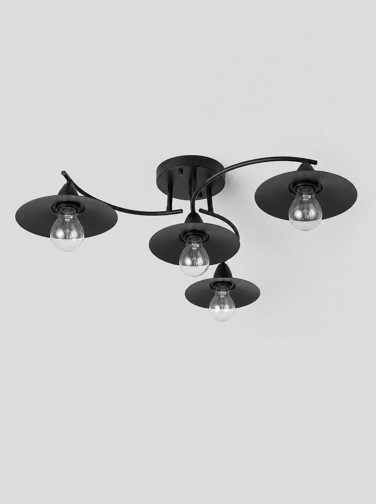 Black four light flush ceiling fixture with cone shades on a light gray studio background