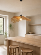 Wide brim rattan pendant hanging low over a light oak kitchen island