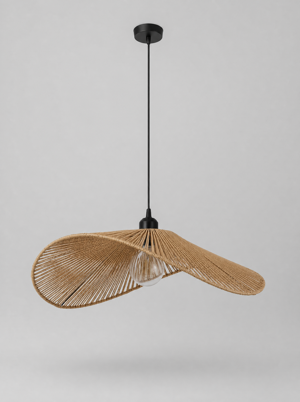 Wide brim woven rattan pendant light on a light gray studio background