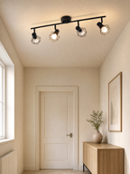 Rounded cage spot bar lit on the ceiling of a bright hallway