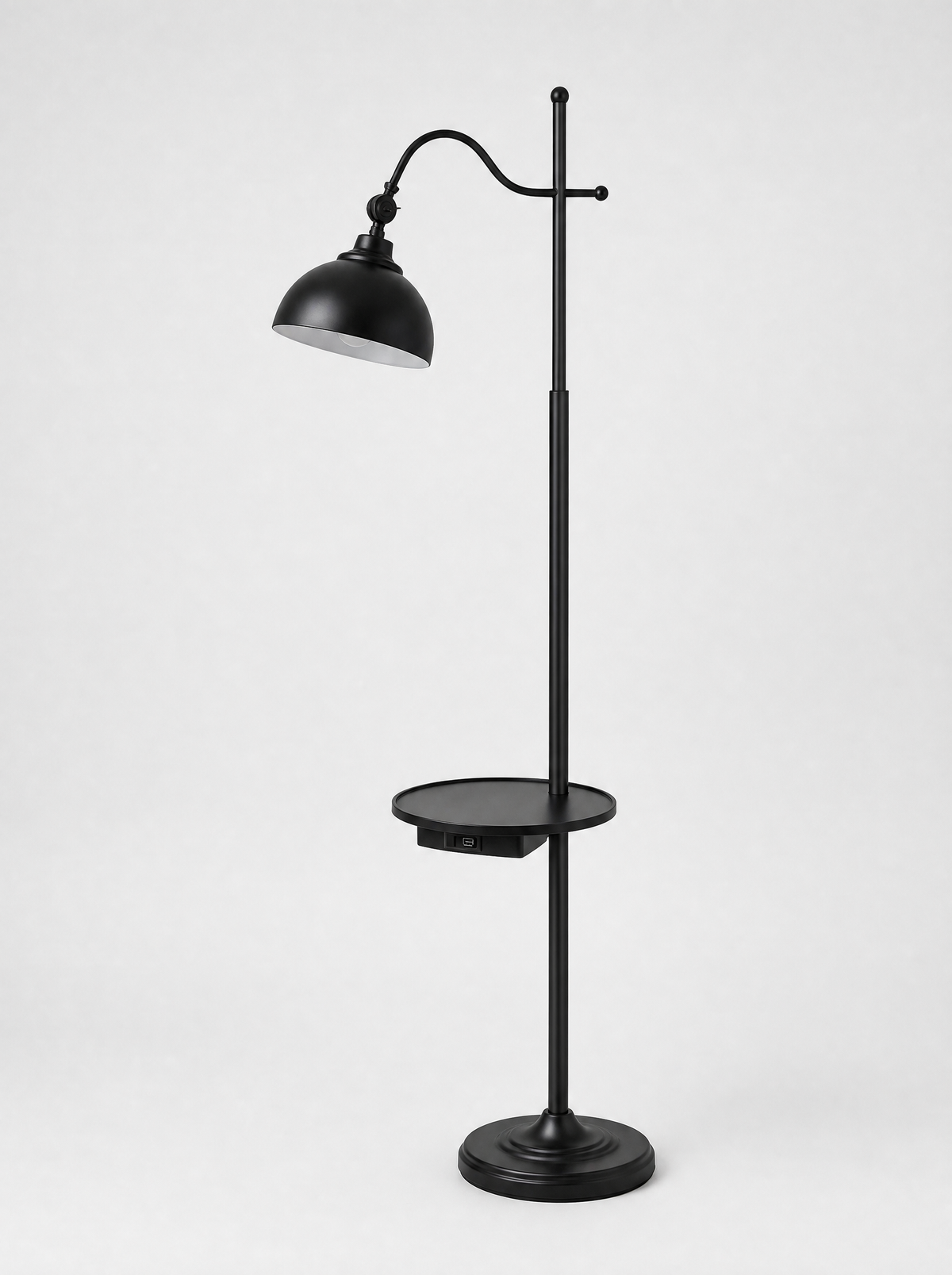 Black floor lamp with an adjustable head, side tray and two USB ports on a light gray studio background