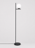 Black floor lamp with a single opal glass globe on a light gray studio background