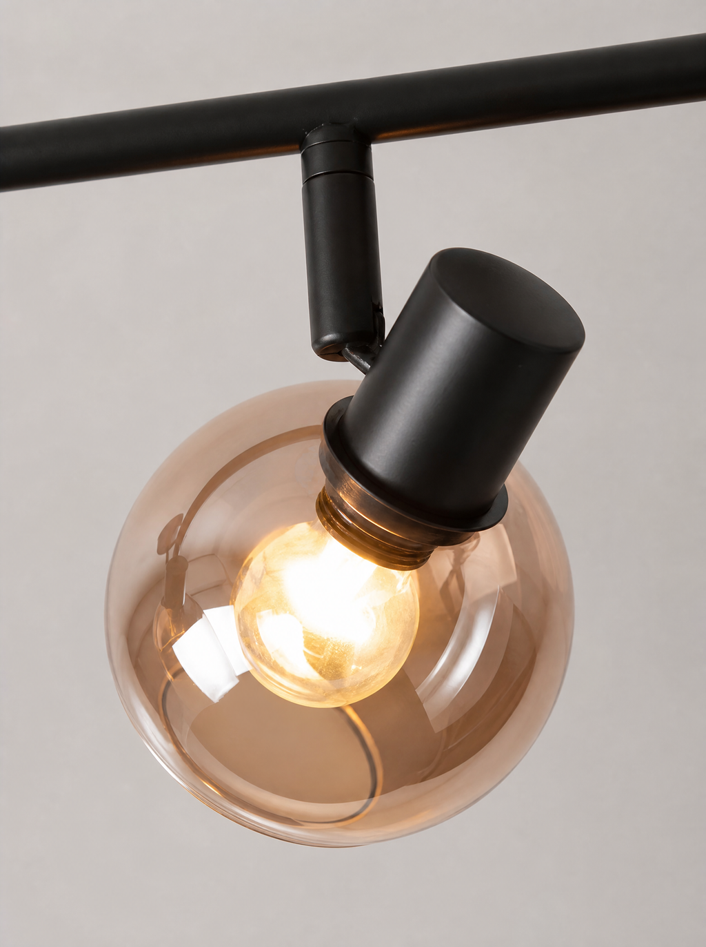 Close up of one smoked glass globe and the black swivel joint