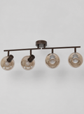 Black four head ceiling spot bar with smoked glass globes on a light gray studio background