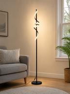 Twisted ribbon LED floor lamp lit beside an armchair in a living room