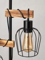 Close up of the wood arm where it meets the black wire cage shade