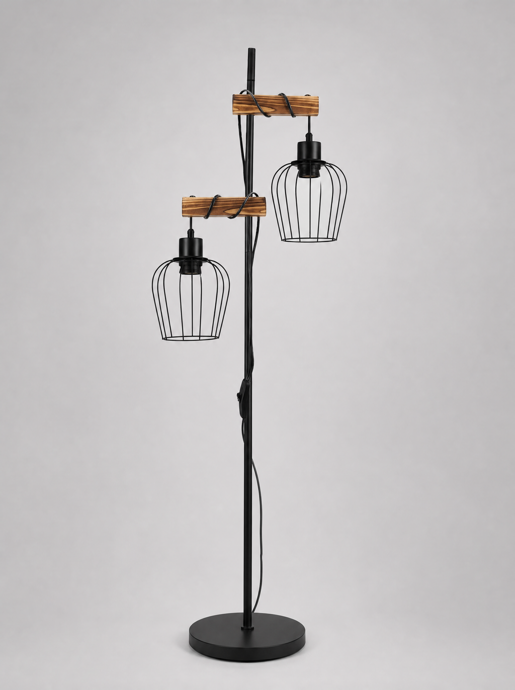 Black floor lamp with two wire cage shades on wood arms on a light gray studio background