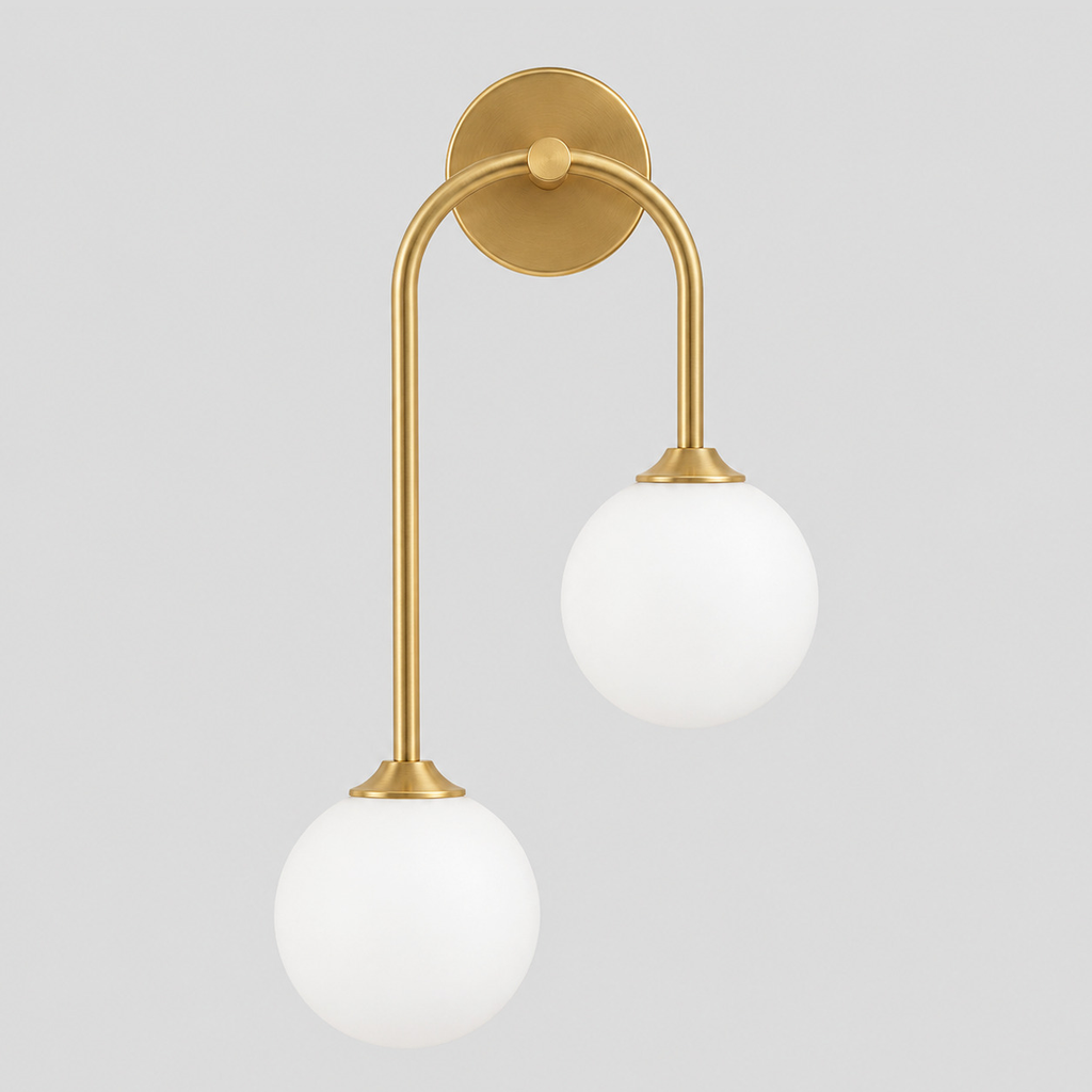 Brass asymmetric double-globe arch wall sconce switched off on a light gray studio background, in its Right shape