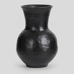 Textured ceramic vase in Black on a light gray studio background.