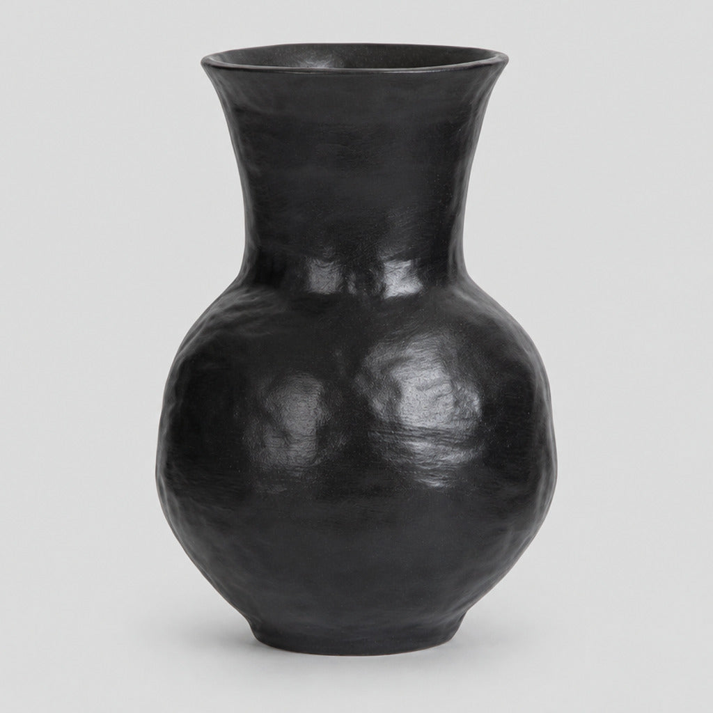 Textured ceramic vase in Black on a light gray studio background.