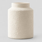 Textured White ceramic jar vase on a light gray studio background.