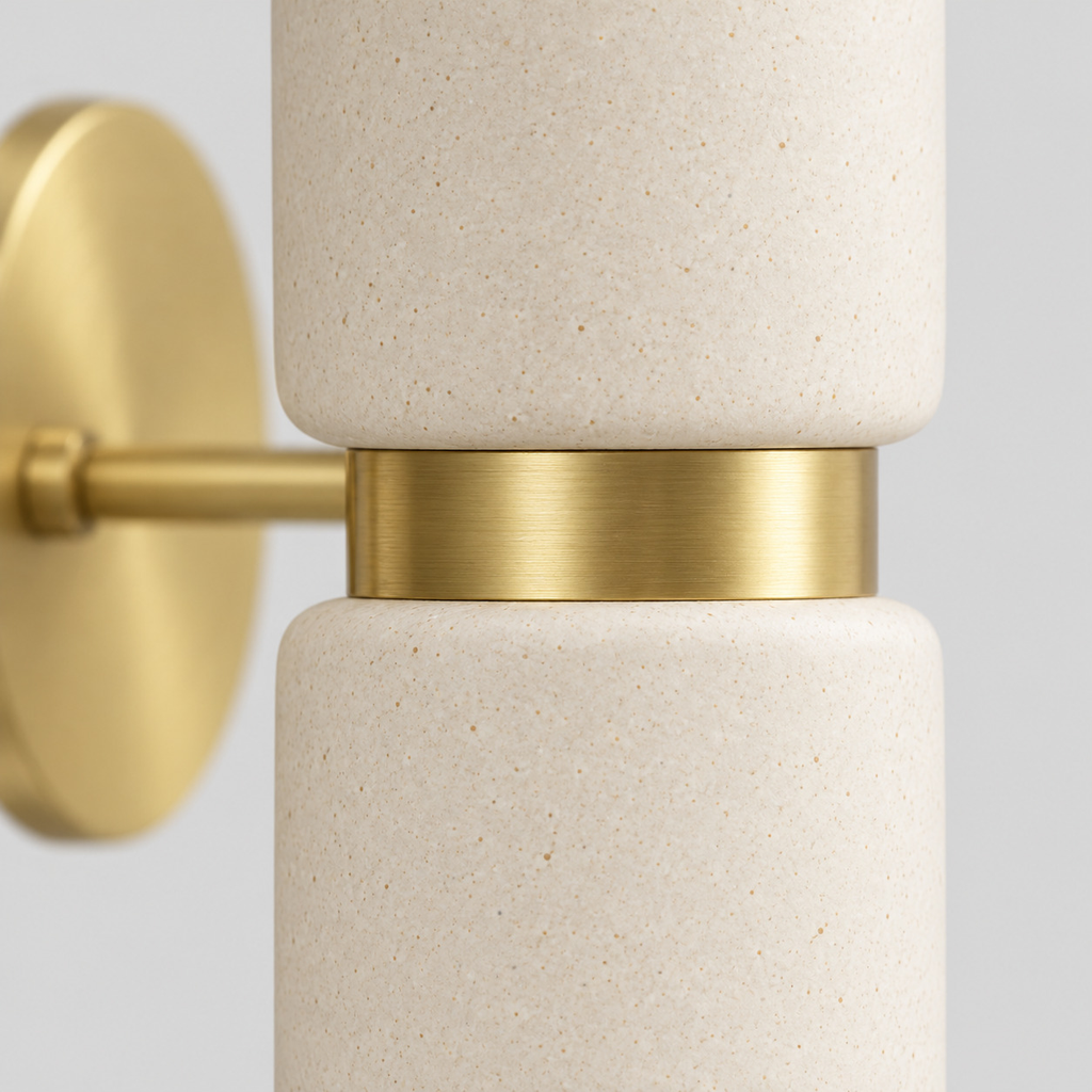 Close up of the finish at a seam of the metal body of the brass dual-light ceramic wall sconce