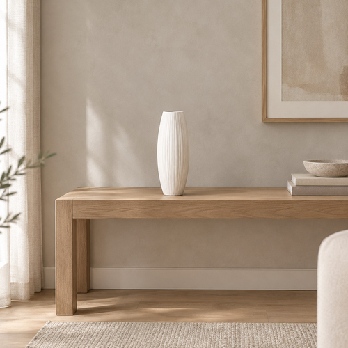 Matte white ribbed ceramic vase on an oak console table in a calm room