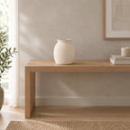 Off-white ceramic vase on an oak console table in a calm room.