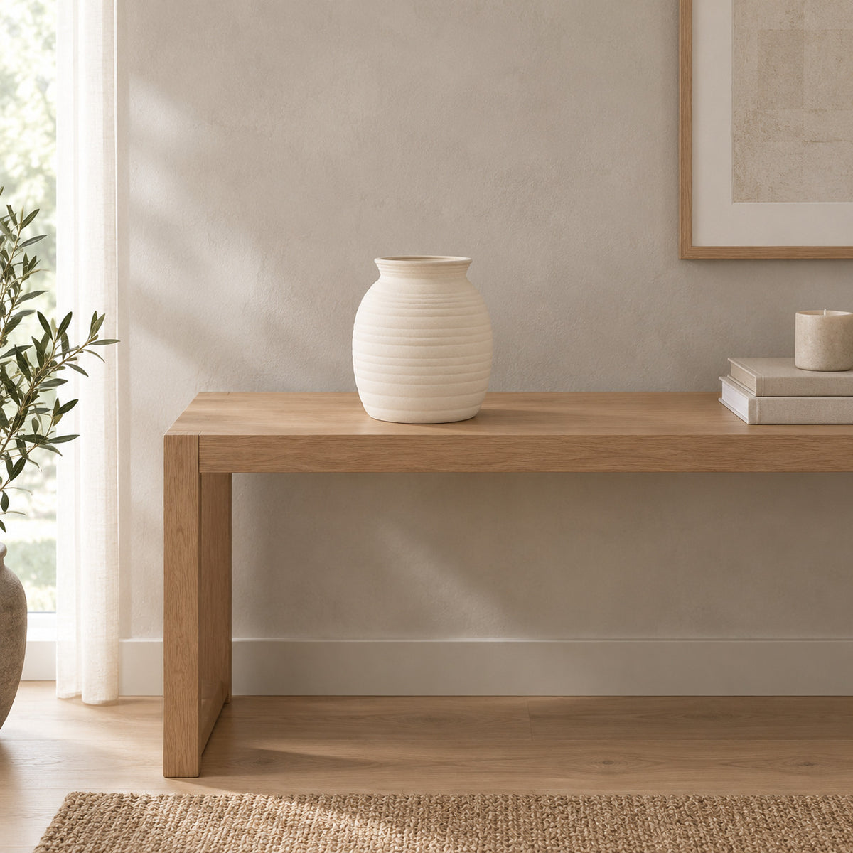 Off-white ceramic vase on an oak console table in a calm room.