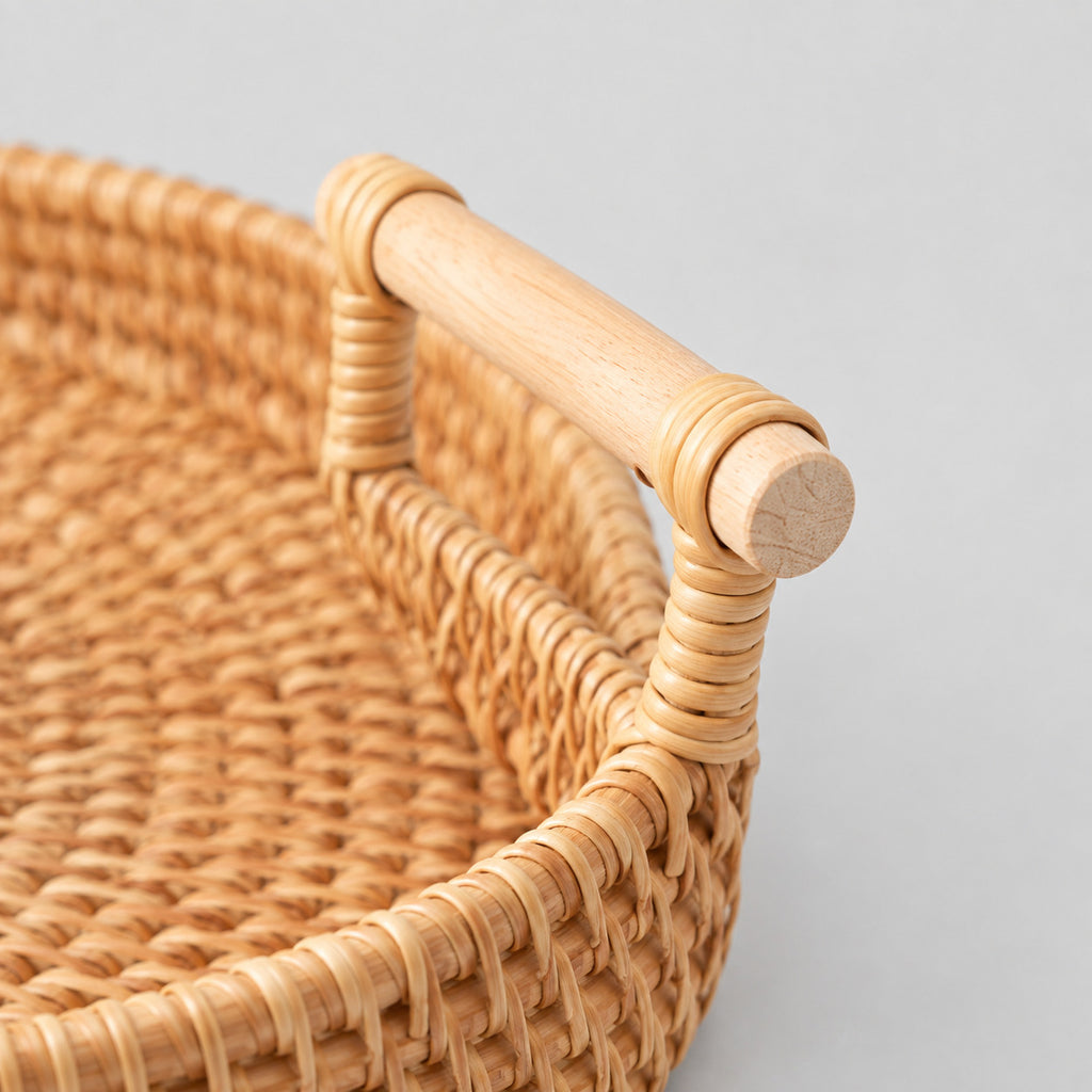 Close up of the smooth wooden carry handle of the natural rattan round woven serving tray.
