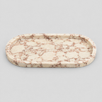 Oval stone vanity tray in Pink Marble on a light gray studio background