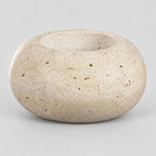 Travertine stone candle holder on a light gray studio background.