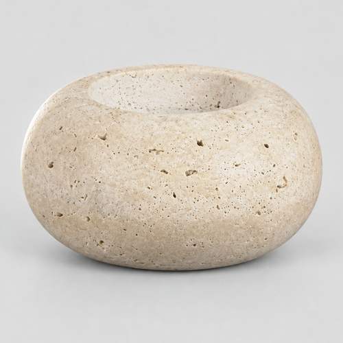 Travertine stone candle holder on a light gray studio background.