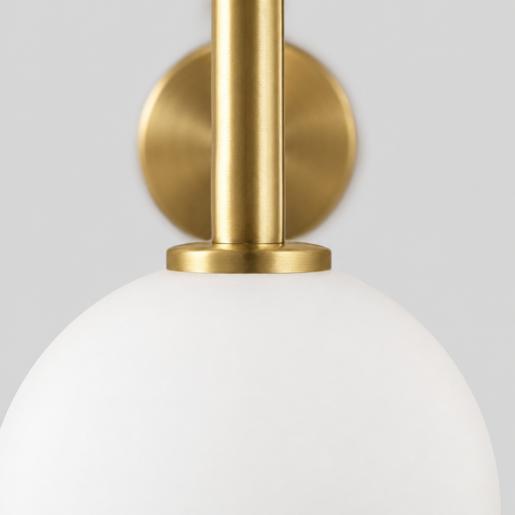 Close up of the rim where the glass shade meets the brass fitter of the brass wall sconce.