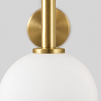 Close up of the rim where the glass shade meets the brass fitter of the brass wall sconce.