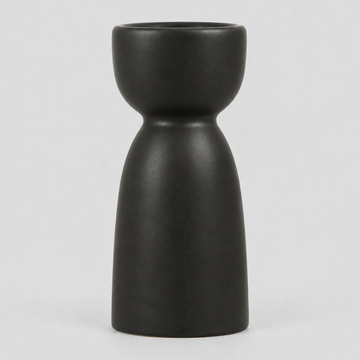 Matte ceramic taper candle holder in Matte Black on a light gray studio background.