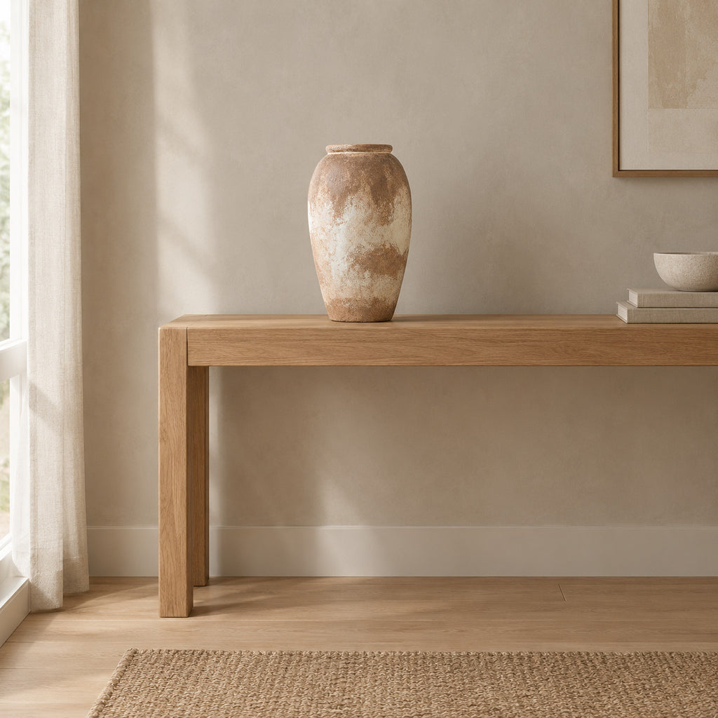 Textured ceramic vase on an oak console table in a calm room.