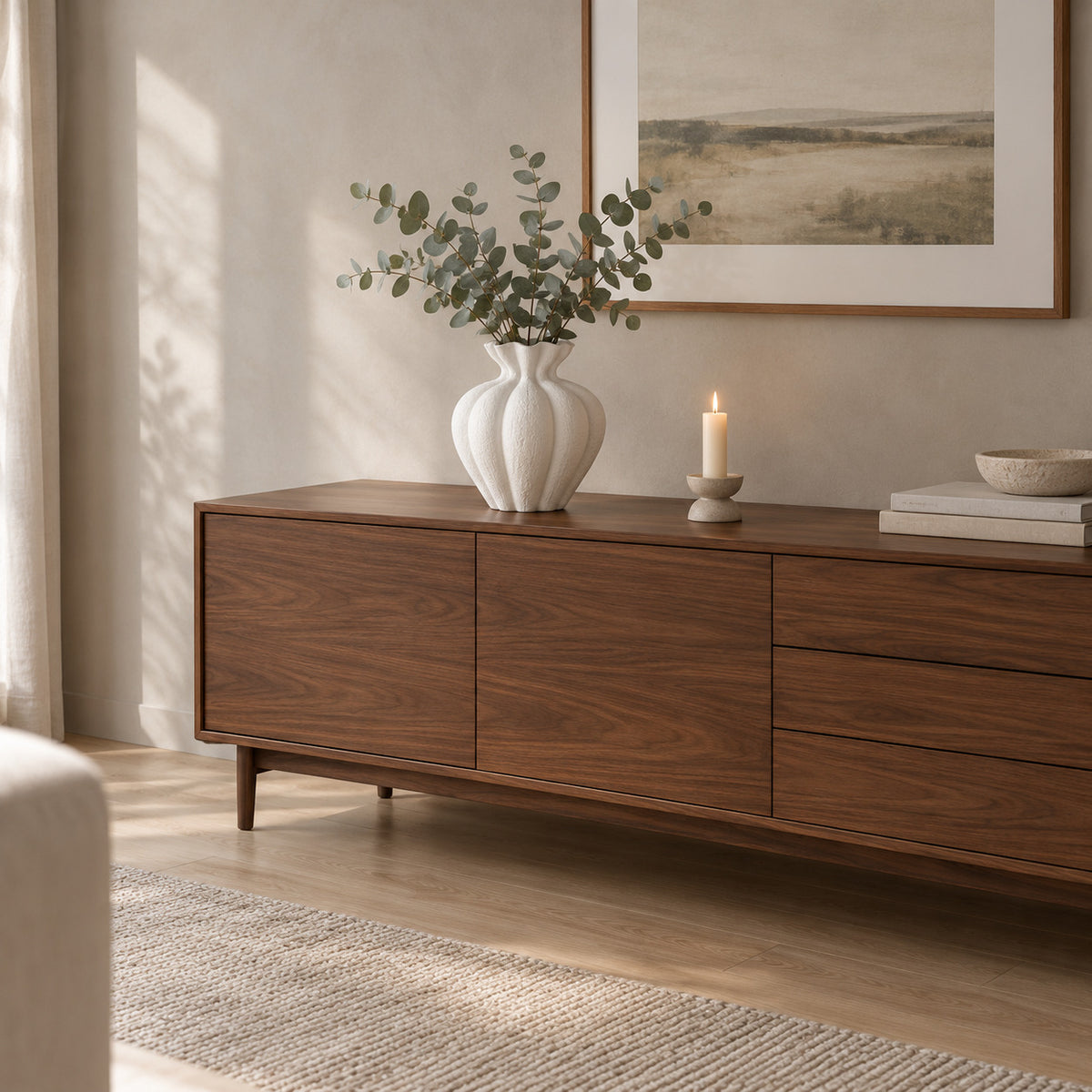 Textured matte white ceramic vase in Matte White on a 160 cm wide walnut sideboard with a bunch of eucalyptus in the vase.
