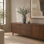 Weathered gray ceramic amphora vase on a walnut sideboard with eucalyptus in the vase