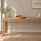 Shallow round woven rattan basket tray in Natural Rattan on a 120 cm wide oak console table in a calm room.