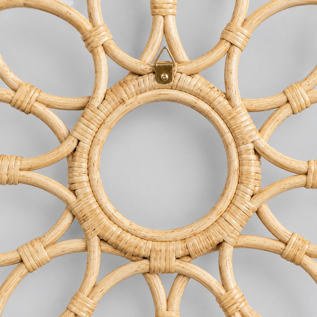 Close up of the tight rattan binding wrapped around the inner circular rim of the decorative looped rattan wall frame in Natural Rattan.