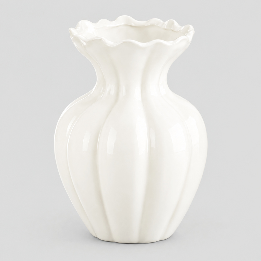White fluted ruffled ceramic vase alone on a light neutral gray studio background.
