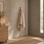 Turned beech wood wall peg in Natural Beech mounted on the plaster wall of an entryway beside a 90 cm wide front door with one linen coat on the hook.