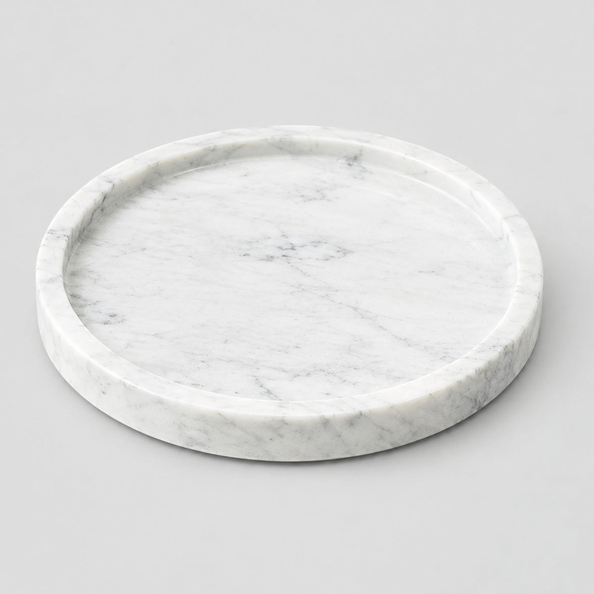 Round marble tray in White Marble on a light gray studio background.