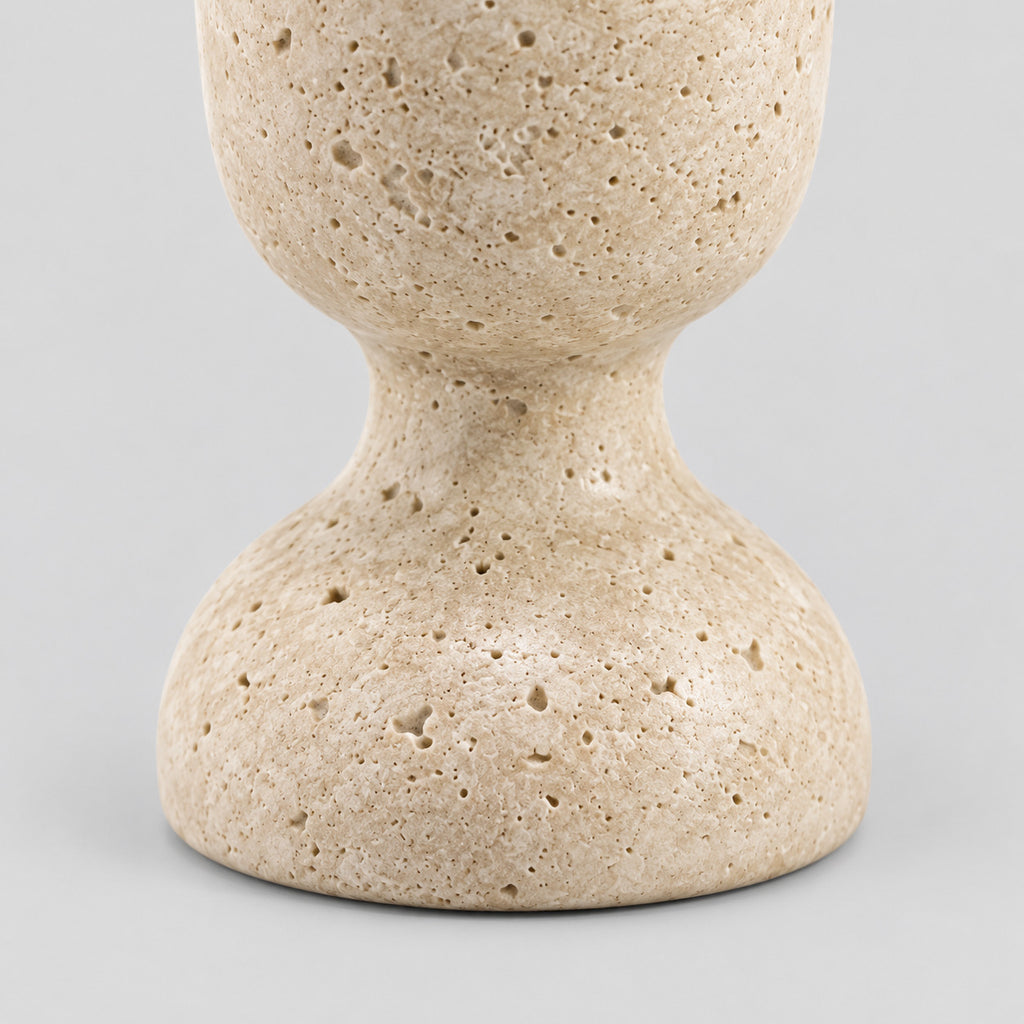 Close up of the rounded pedestal base of the travertine candle holder.
