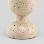 Close up of the rounded pedestal base of the travertine candle holder.