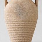 Close up of the weathered sandy glaze along the ribbed lower body of the ceramic amphora vase.