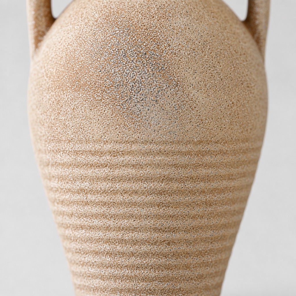 Close up of the weathered sandy glaze along the ribbed lower body of the ceramic amphora vase.
