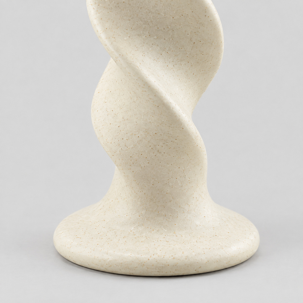 Close up of the smooth circular base of the beige twisted ceramic taper candle holder.