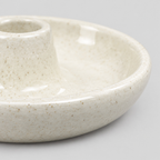 Close up of the smooth rounded rim of the dish of the ceramic taper candle holder in Speckled Off-White