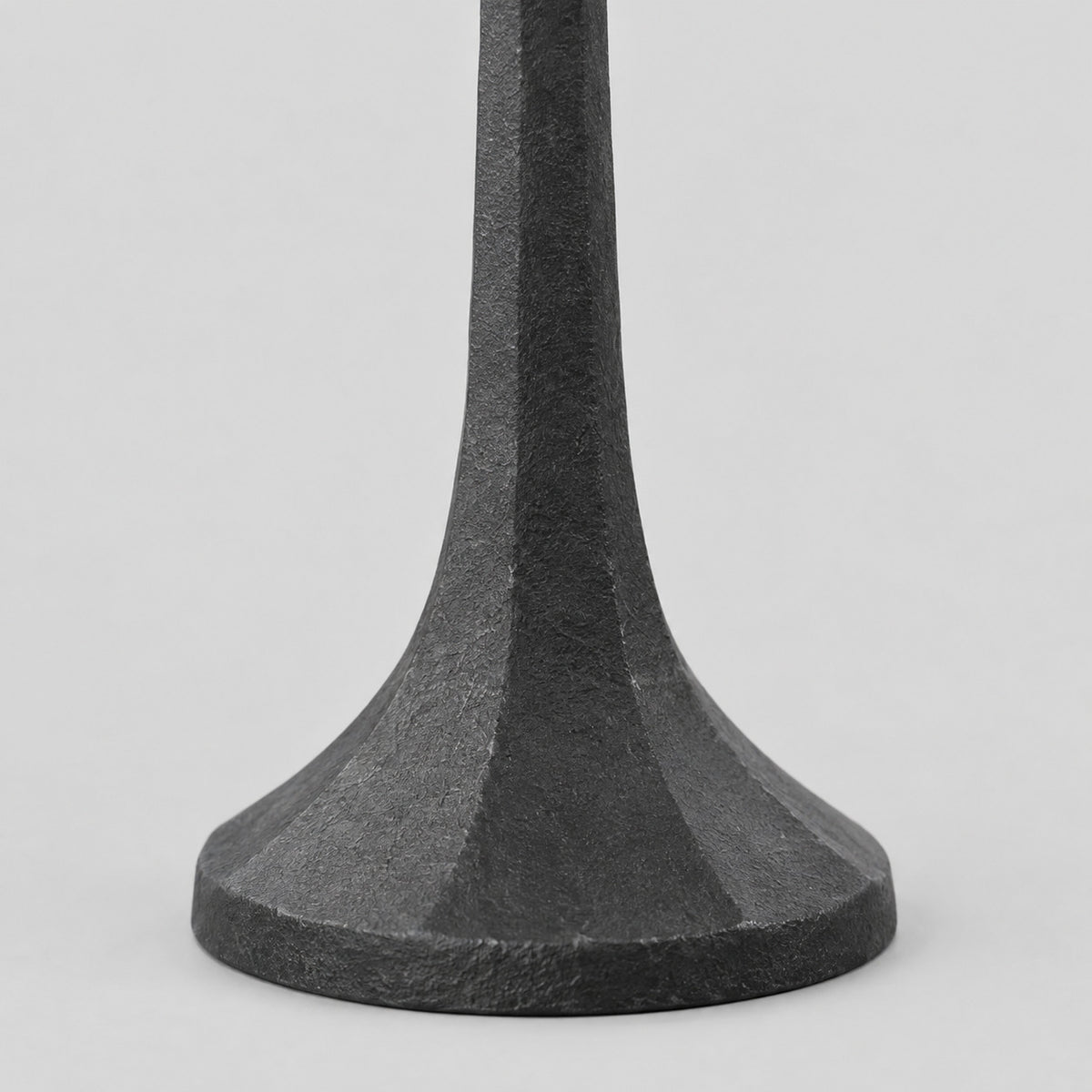Close up of the flared faceted base of the cast iron taper candle holder in Matte Black.