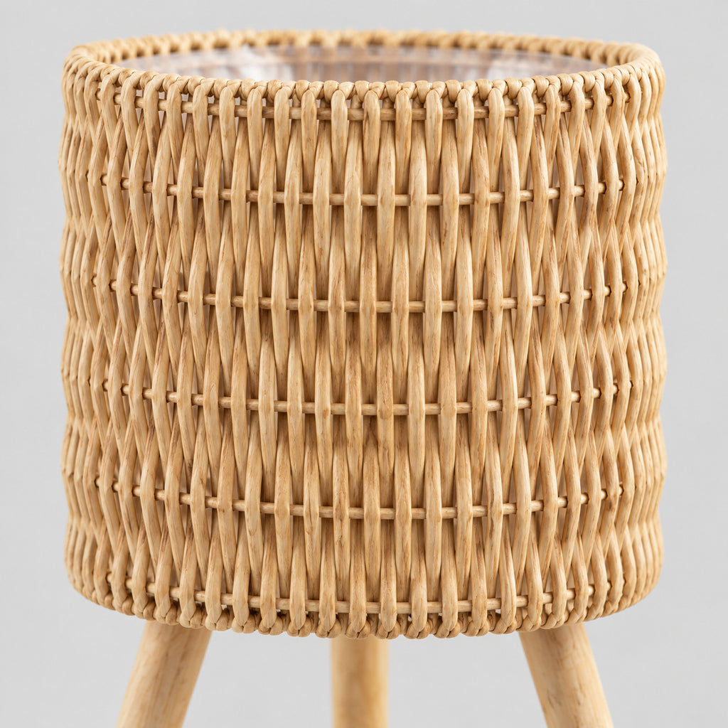 Close up of the vertical weave of the rattan basket on the standing woven rattan planter basket on wooden tripod legs in Natural Rattan.
