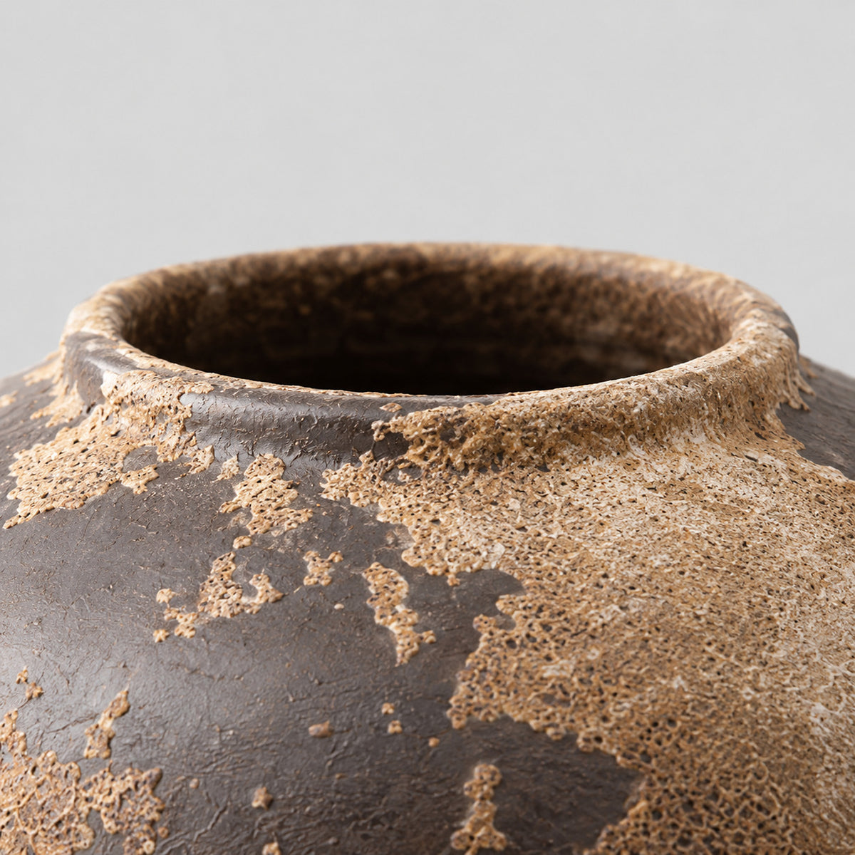 Close up of the smooth rounded ceramic rim of the weathered ceramic vase in Weathered Brown.