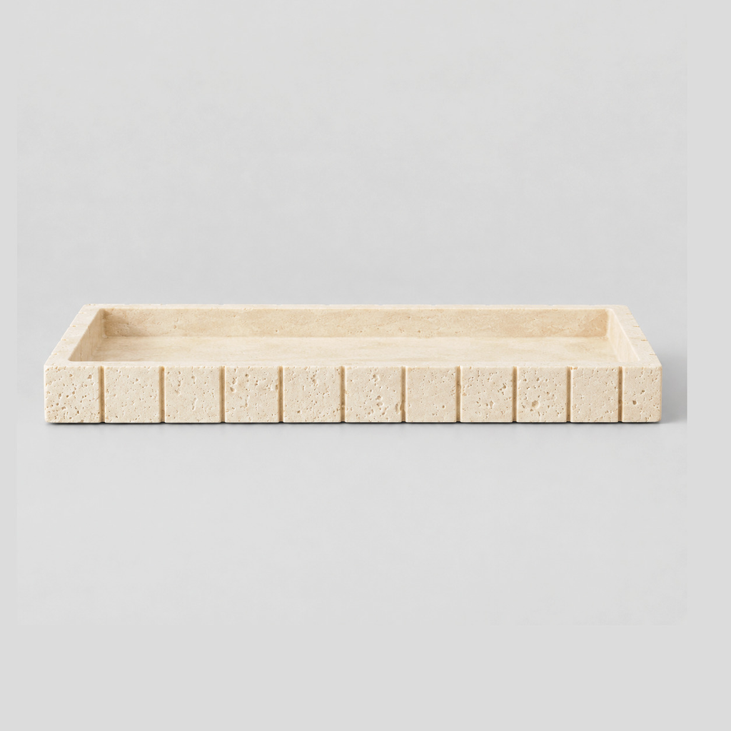 Beige rectangular fluted travertine vanity tray on a light neutral gray studio background.